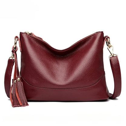 Close-up of wine red cowhide leather handbag, emphasizing material quality.