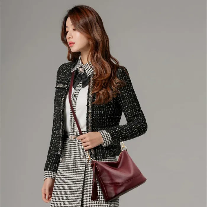 Stylish young woman accessorizing with a red leather tassel handbag for a polished look.