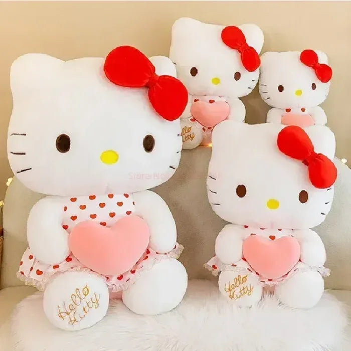 Four Hello Kitty plush toys of various sizes displayed on sofa.