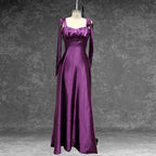 Model twirling in a glamorous purple satin prom dress by a window. The shiny fabric and full skirt make it ideal for evening.