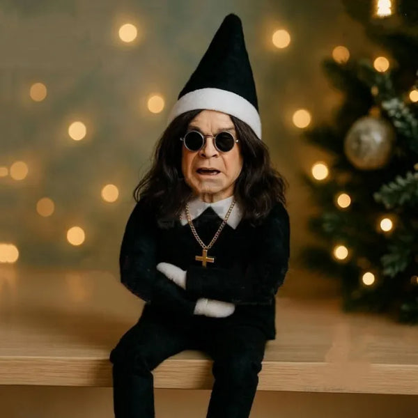Ozzy Osborne Elf on the shelf doll in black outfit with sunglasses and Christmas lights in background