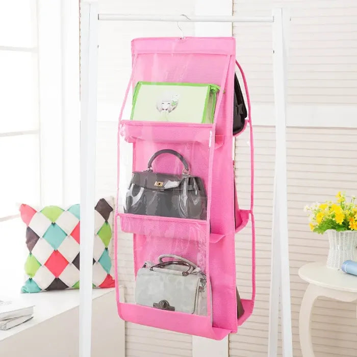 Pink hanging organizer featuring various handbags.