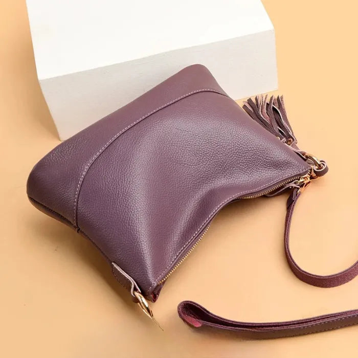 Purple leather crossbody bag with chic tassel, perfect for daily use and style.