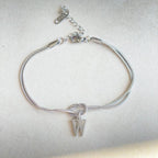 Silver bracelet with a letter 'W' charm on a light gray background