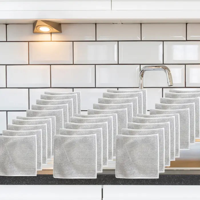 set of 30 silver mesh dish cloths neatly arranged on a kitchen sink, showcasing their durable and reusable design for effective cleaning.