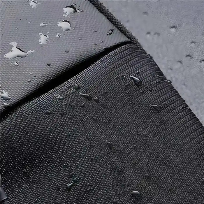 Close-up of water droplets on gray and black textured fabric, demonstrating the sling bag's water-resistant properties