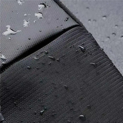 Close-up of water droplets on gray and black textured fabric, demonstrating the sling bag's water-resistant properties