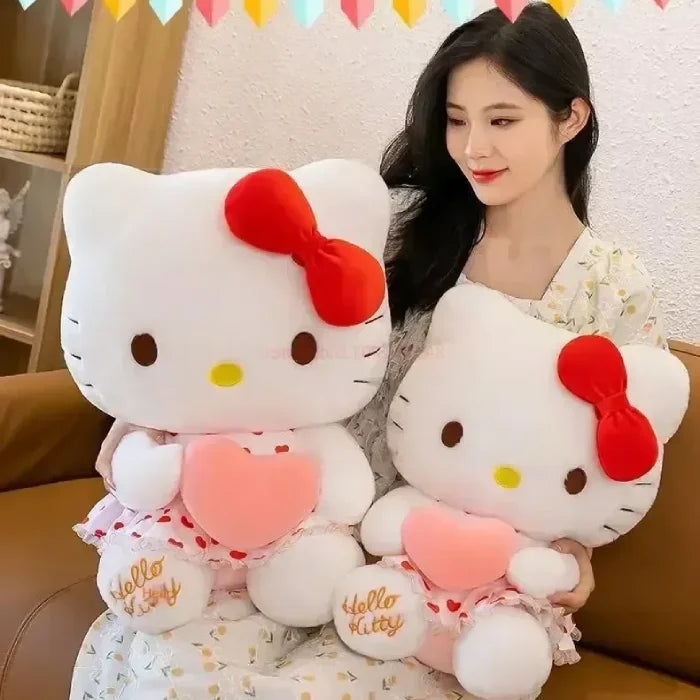 Woman seated, embracing two Hello Kitty plush toys, with party decor.