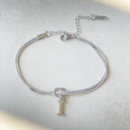 Silver bracelet with a letter 'I' charm on a light gray background