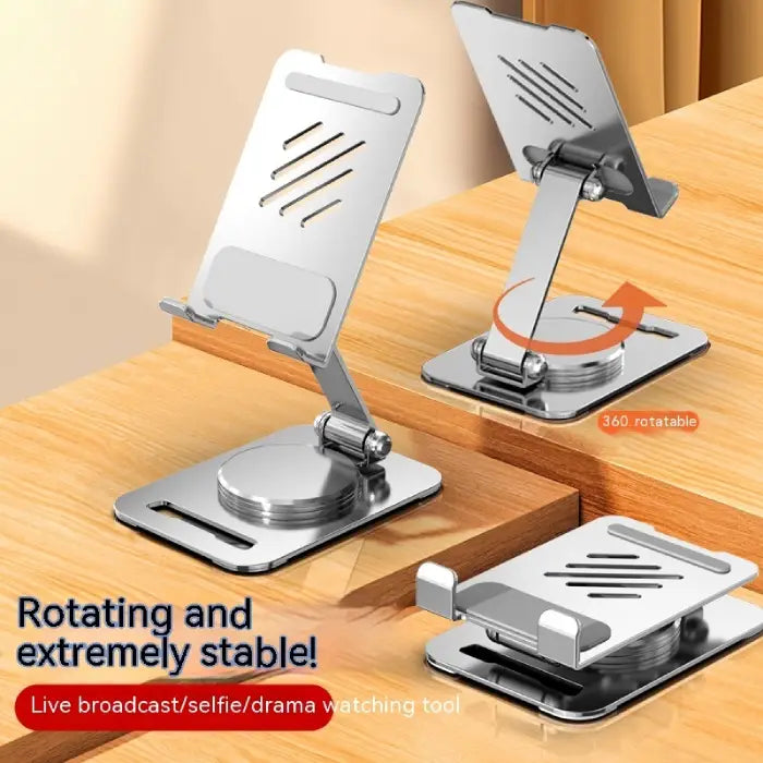 Silver phone stand with rotating base on wooden desk surface, showing stability and adjustment features