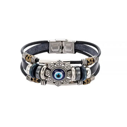 Adjustable evil eye bracelet with leather straps and intricate metallic charm on a plain white background.