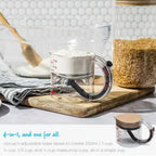 Adjustable measuring cup holding flour with raised base for multiple cup measurements.