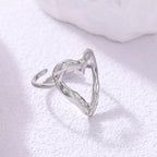 adjustable open heart ring in silver with hammered texture displayed on bright surface, offering a minimalist modern jewelry style