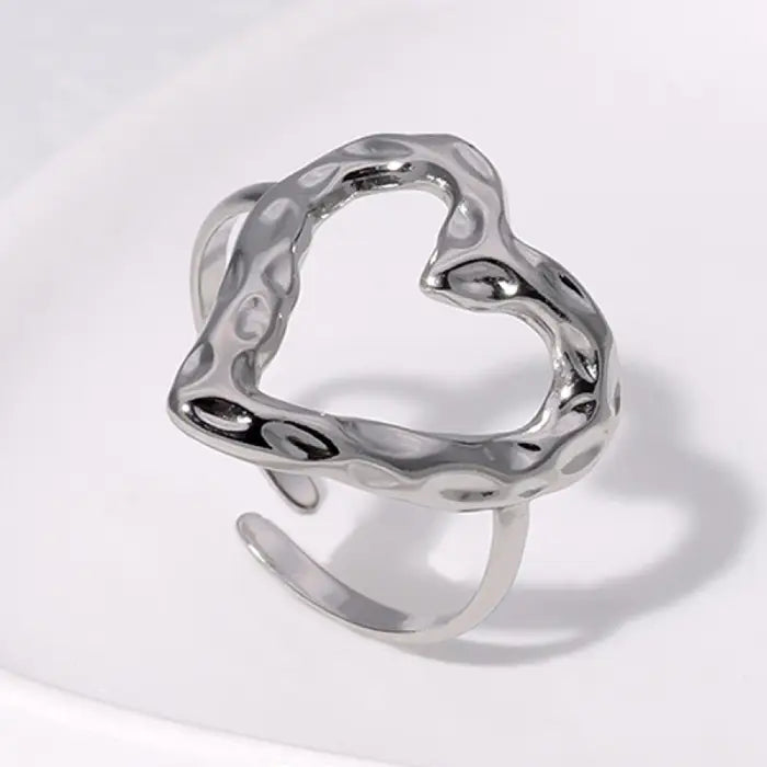 adjustable open heart ring in textured silver design shown on white surface, offering a modern minimalist sculpted style ideal for gifting