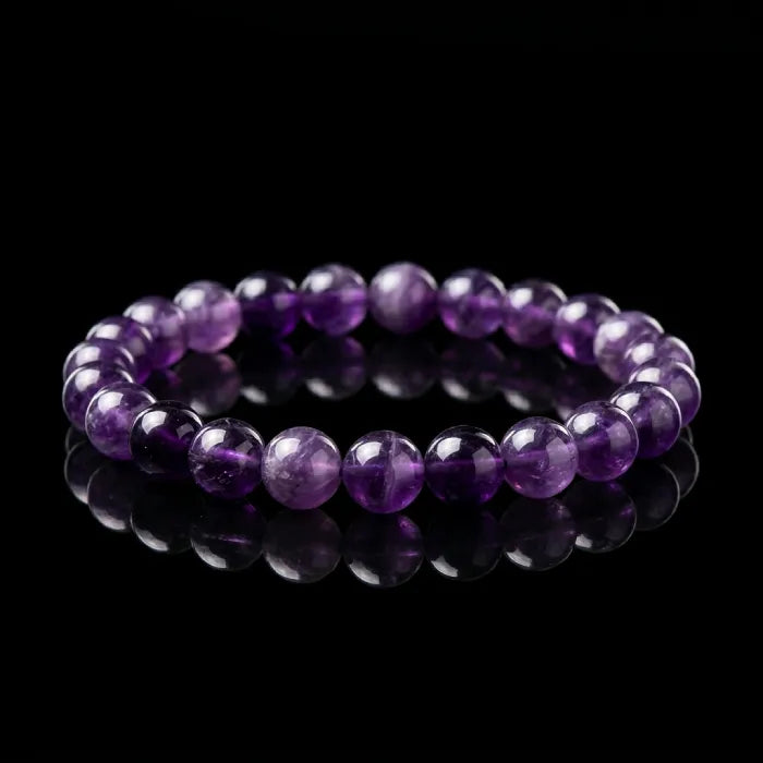 Amethyst jewelry bracelet with glossy deep purple beads on reflective black surface, luxury gemstone accessory for peaceful energy
