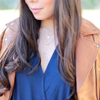 Angel wing necklace in gold worn layered with heart pendant, offering delicate meaningful jewelry styling with soft symbolic angelic appeal