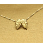Angel wing necklace in gold with textured wing pendant on a fine chain, offering meaningful symbolic jewelry perfect for thoughtful gifting