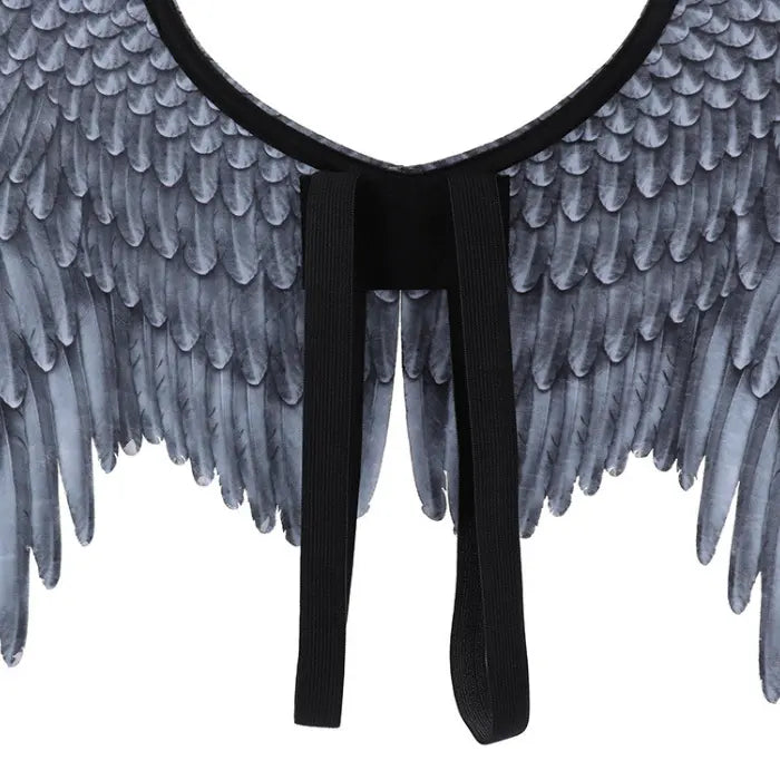 Angel wings closeup of black shoulder straps and gray feather texture in symmetrical wing layout.