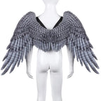 Angel wings with dark feather look on white mannequin with black straps and layered wing texture.