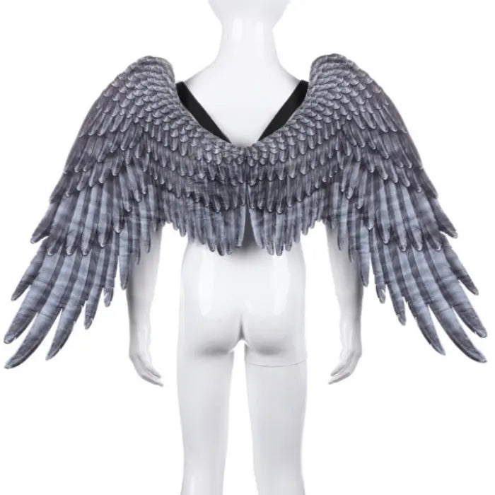 Angel wings with dark feather look on white mannequin with black straps and layered wing texture.