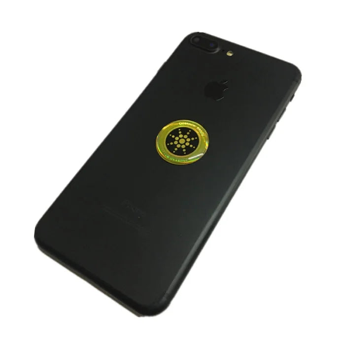Anti radiation sticker placed on center of black smartphone with inset image showing usage.