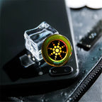 Anti radiation sticker on black phone near ice cube reflecting light and placed on textured surface.