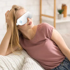 Woman using Anti-Wrinkle Eye Massager while relaxing at home on a cozy couch.