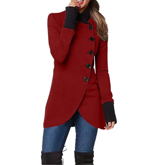 Asymmetric wrap coat in red with side buttons, long sleeves, and curved hem, styled with jeans and boots.