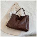 Autumn Shoulder bag in chocolate brown leather shown with cream outfit and glass cup