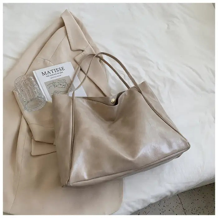 Autumn Shoulder bag in light beige faux leather styled on bed with neutral-toned outfit