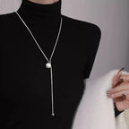 ball loop chain necklace long silver chain with ball pendant styled with black turtleneck