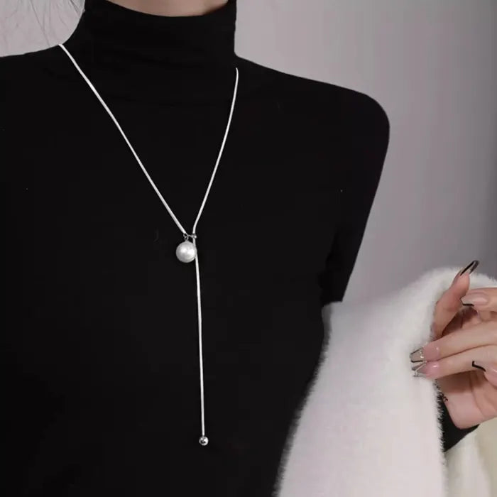 ball loop chain necklace long silver chain with ball pendant styled with black turtleneck
