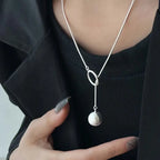 ball loop chain necklace silver drop pendant with loop detail styled over dark outfit