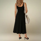 Back view of the timeless black sleeveless A-line midi dress, highlighting its simple scoop back design. Shop this versatile casual midi dress with slit for any occasion.