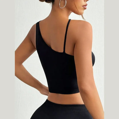 Front view of black cross-strap crop top with keyhole detail, worn by woman with toned abdomen and navel piercing