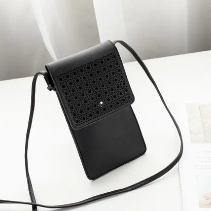 Black leather crossbody phone bag with perforated flap design, perfect for carrying essentials stylishly.