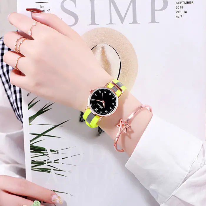 Women's watch with a black dial and neon yellow strap, styled with a rose gold star bracelet.