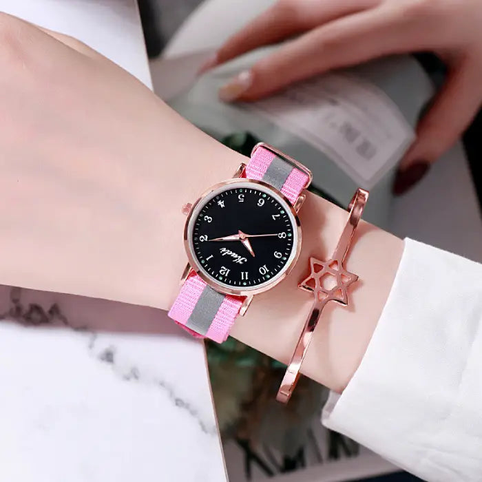 Women's watch with a black dial and pink strap, complemented by a rose gold star bracelet.