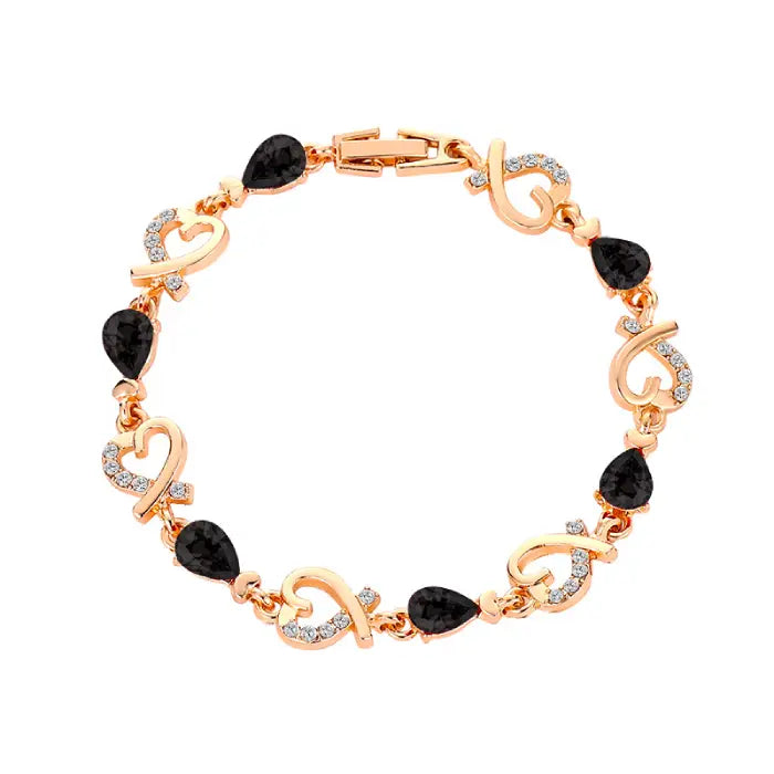 Black gemstone teardrop bracelet with gold heart accents, ideal for formal and chic occasions.