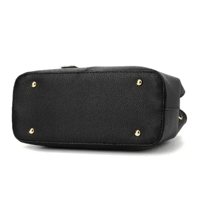 Bottom of black leather handbag with gold studs for durability and protection against wear.