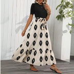 Black maxi dress with slit boho style, beige patterned skirt tiered hem ideal for beach or casual wear.