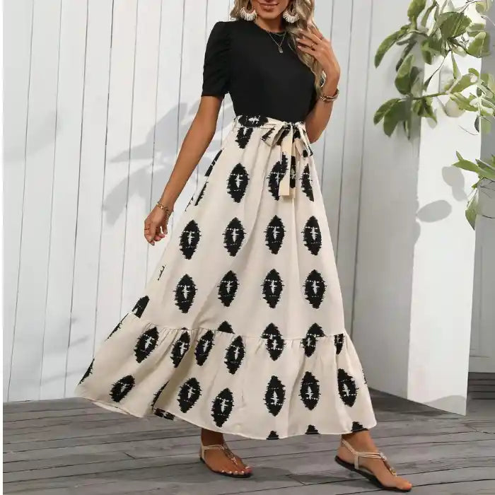 Black maxi dress with slit boho style, beige patterned skirt tiered hem ideal for beach or casual wear.