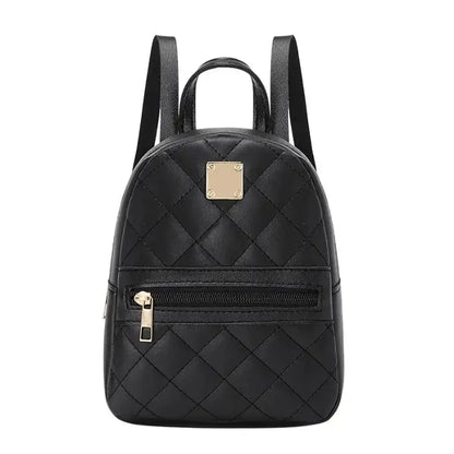 Front view of black quilted mini backpack with gold metal plate, zipper pocket, and adjustable shoulder straps