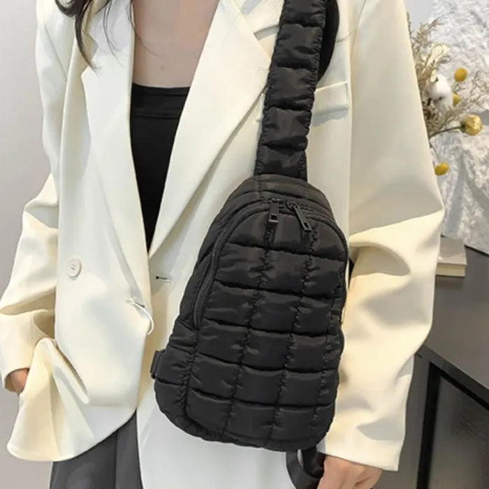 Black quilted sling bag paired with white blazer, showcasing elegant and minimalist style