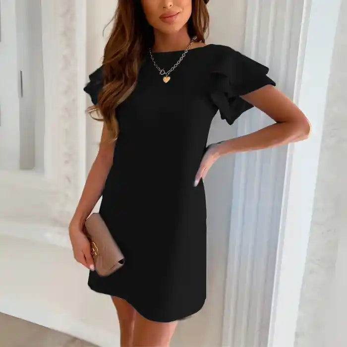 Black ruffle sleeve shift dress front view styled with clutch and heart chain necklace.
