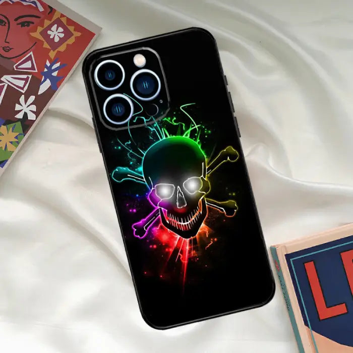 Black skull with crossbones phone case featuring a glowing rainbow gradient for a bold statement.