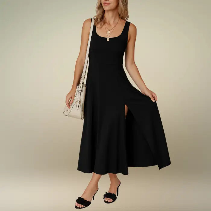 Woman models a classic black sleeveless midi dress featuring a scoop neck and A-line skirt with slit. Order this essential casual midi dress for your wardrobe now.