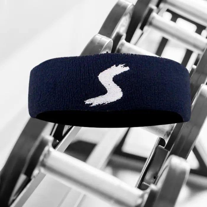 Black terry cloth sweatband with a white logo, designed for comfortable sports and workout use.