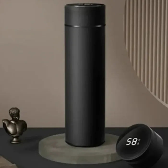 Matte black thermos bottle with digital temperature display on marble surface, decorative bust nearby