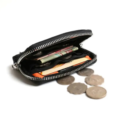 Open black wallet showing compartments filled with coins, cash, and cards for practical organization.